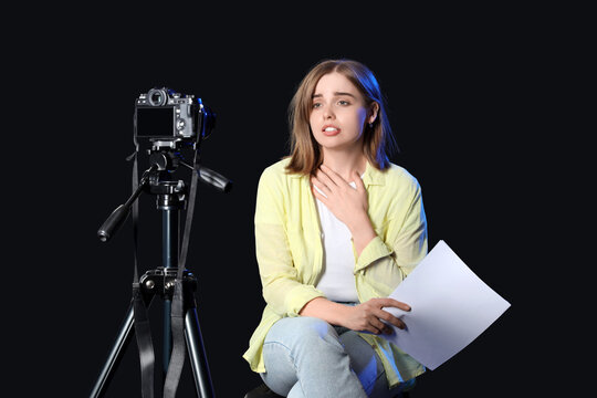 Young actress recording her audition on black background