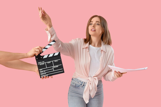 Young actress and female hands with movie clapper on pink background - Powered by Adobe