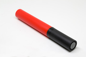 Angled close-up of a red-and-black handheld ball pump, isolated on white