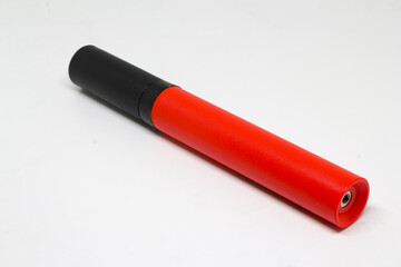 Angled close-up of a red-and-black handheld ball pump, isolated on white