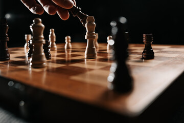 A black king advances against a white king in a decisive endgame under low key light, representing...