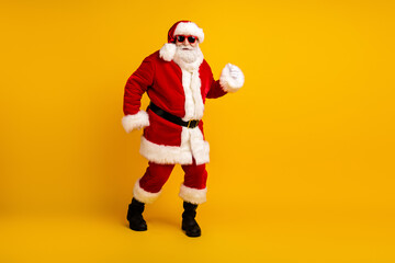 Santa in red suit with white fur dancing against a bright yellow background for festive holiday season Christmas cheer and playful celebration