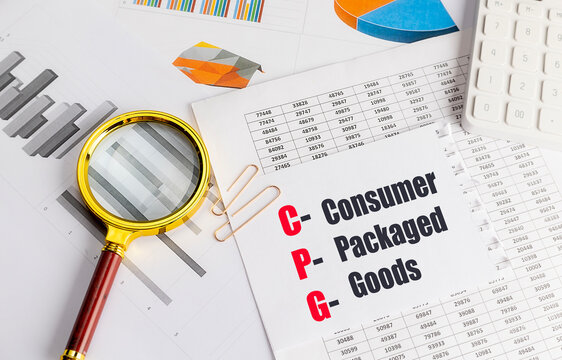 Abbreviation CPG meaning consumer packaged goods written on paper with charts, magnifying glass and calculator