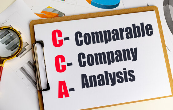 Abbreviation CCA meaning comparable company analysis written on clipboard with financial charts and magnifying glass