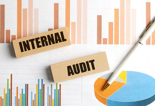 Wooden blocks with the words helpful tips on financial charts background with pen, representing advice