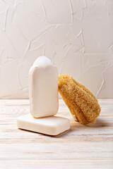 Health and hygiene. Natural soap bars stacked beside loofah sponge on wooden surface, creating serene and inviting atmosphere, showcasing organic textures and materials for calming bathroom aesthetic