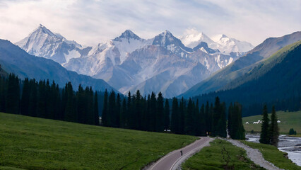 Winding Road Through Alpine Valley with Snowcapped Mountain Peaks