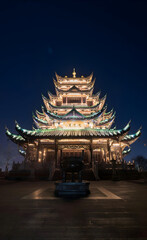 Fototapeta premium Illuminated Chinese Pagoda Temple at Evening Against Dark Sky