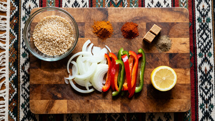 Rice peppers onions spices lemon prep on wooden board for Middle Eastern dish