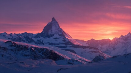 A mountain range with a snow covered peak and a sunset in the background. The sky is a mix of pink and purple hues