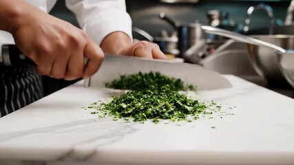 Chef skillfully chops fresh herbs in a modern kitchen during meal preparation
