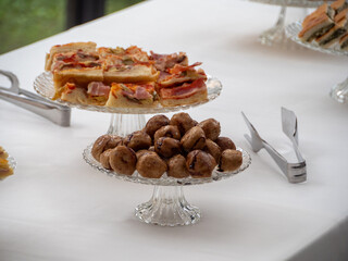 Elegant Glass Cake Stands Display Savory Appetizers and Gourmet Food Items During a Buffet Event Celebration Catering Service