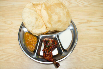 flavors of India with this vibrant thali! Featuring crispy puri, chhole, tandoori chicken and yogurt. Perfect for food blogs and menus.