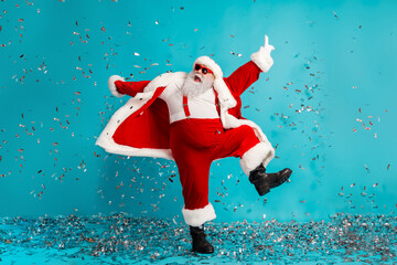 Santa Claus dancing in a bright blue studio with confetti perfect for Christmas campaigns and...