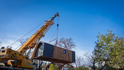 The process of moving a house using a truck crane.