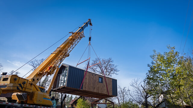 The process of moving a house using a truck crane.