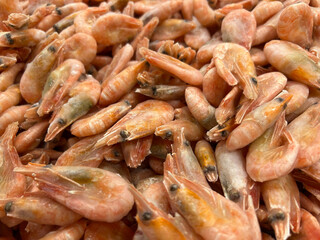 Large glass dish with a large frozen shrimp on wooden gray background in rustic style, empty space for your text