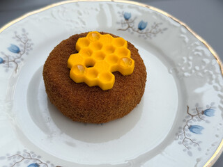 Closeup of honey-inspired dessert with yellow decoration. Confectionery art, patisserie elegance, and gourmet sweetness concept.