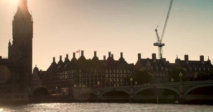 4K video of red buses, taxis, traffic and people on Westminster Bridge over the River Thames next to Big Ben and The Houses of Parliament at dusk