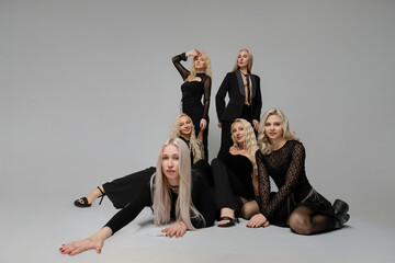 Group of women in black outfits posing creatively in a studio setting for fashion photography
