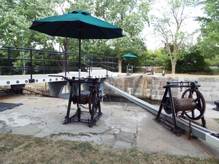 A section of the Hogs Back Locks on the Rideau Canal, featuring the historic mechanical gear and chain machinery used to operate the lock gates.
