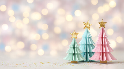 Three pastel paper Christmas trees with golden stars on a festive bokeh background with copy space