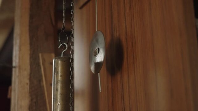 The pendulum of an old clock is swinging