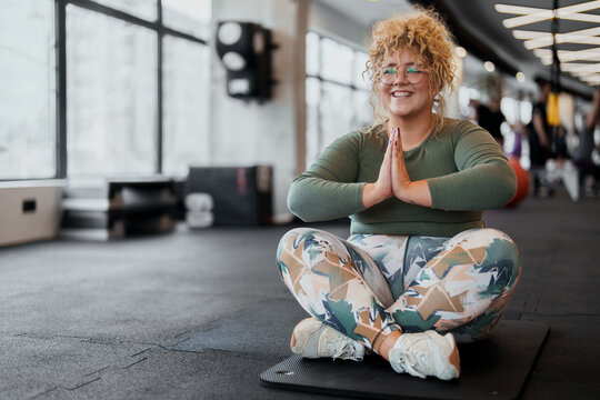 Bright natural light woman meditating calmly indoors in modern gym environment
