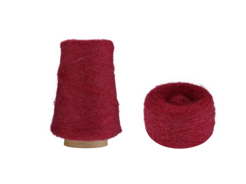 A Red fluffy yarn set with a spool on a cardboard bobbin and a smaller ball, isolated on a white background. Ideal for knitting, crocheting, or craft projects, this fresh yarn adds a cool,
