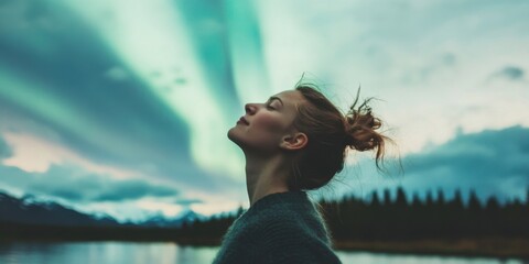 A Captivating Woman Standing Majestically Under the Northern Lights in the Natural World