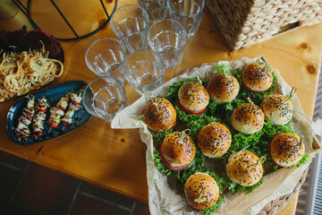 Party buffet table displaying mini sliders and appetizers