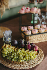 Catering buffet table with fresh fruit and small cakes