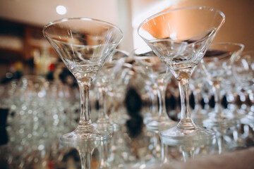Obraz premium Empty martini glasses on a reflective surface preparing for an event