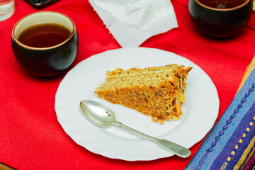 Sliced Carrot Cake with Creamy Frosting, Coffee, and Patterned Napkin on Rustic Breakfast Table