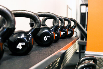 kettlebell dumbells on a rack, in a gym