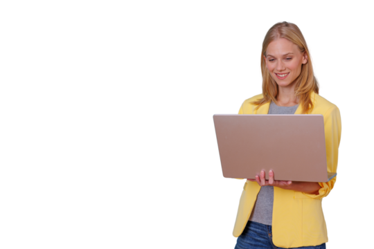 Young businesswoman in yellow jacket smiling while working on laptop, standing, transparent background for easy overlay