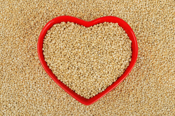 white quinoa seeds in ceramic bowl as a background. Top view. Flat lay