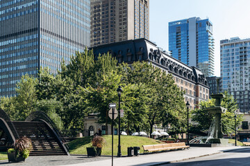 Montreal, Canada - August 11, 2025: View of Dorchester Square with trees, fountain, and modern skyscrapers in downtown Montreal