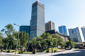 Montreal, Canada - August 11, 2025: View of Dorchester Square with trees, fountain, and modern skyscrapers in downtown Montreal