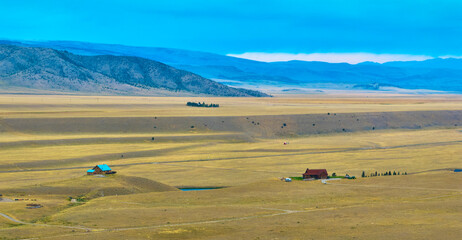 Obraz premium Aerial Wyoming Ranch Houses Expansive Plains and Distant Mountain Panorama