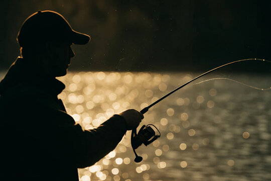 Silhouette of an angler casting a spinning rod at golden sunrise, fishing line arcing over shimmering water with dramatic bokeh.