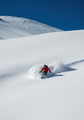 Dynamic shot of a rider navigating deep powder snow on a pristine mountain range during a cold, bright winter excursion ,cold ,winter ,jump