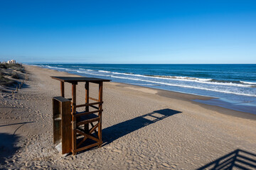 Lifeguard tower casting shadow on empty cullera beach
