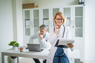 Medical professionals working in a clinic office consulting patient files