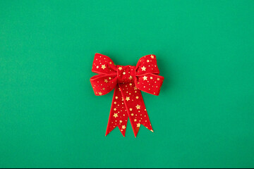Red Christmas Bow with Golden Stars on Green Background
