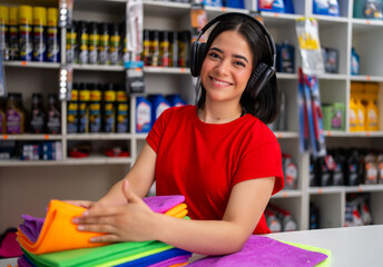 Female worker happily organizing cleaning cloths in an auto parts retail store
