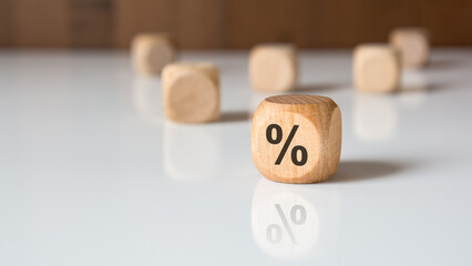 Wooden block with percent symbol on white table symbolizing interest rate and finance.