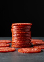 Fiery red round slices of cured spicy sausage, commonly known as pepperoni, stacked or scattered, perfect for pizza and savory dishes ,texture ,heat ,dish