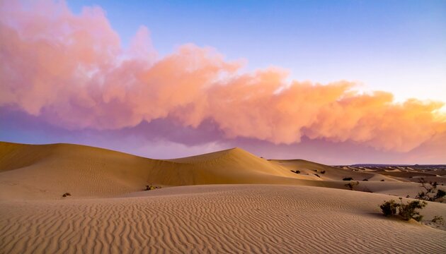 Desert dunes glow beneath colorful clouds