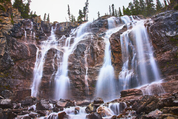 Tangle Falls Waterfall Cascading Over Rocky Cliffs with Lush Forest Jasper Canada © Nicholas J. Klein